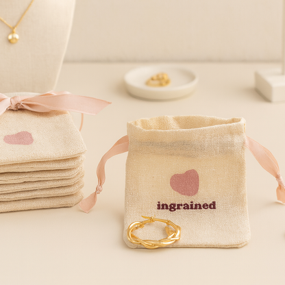 Beige jewelry bags with pink ribbons and 'ingraind' branding on a light background.